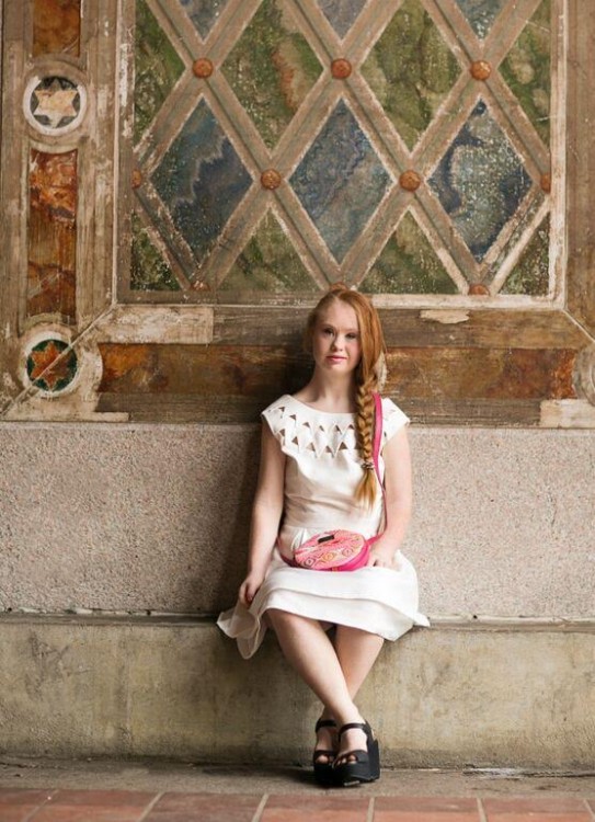 Madeline Stuart sitting in front of a building