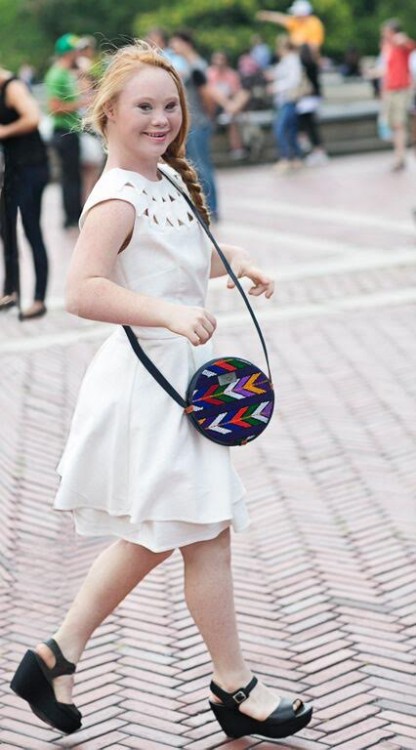 Madeline Stuart walking with a colorful purse