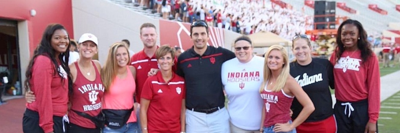 What I Want My Employer to Know About My Autism and Me A group of people linking arms standing on a college footbal field