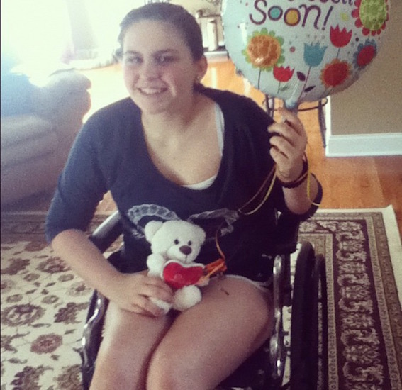 young woman with 'get well soon' balloon and teddy bear