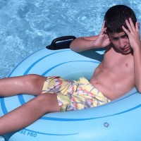 Boy floating in an inflatable tube on a pool