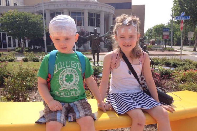 two children sitting on a bench holding hands