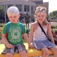 two children sitting on a bench holding hands