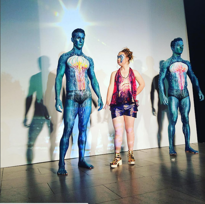 Madeline Stuart next to two men at FTL Moda 2015 NYFW show