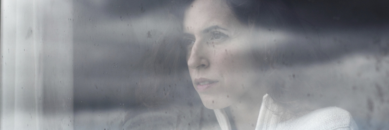 What You Should Know Before You Tell Me to 'Snap Out of' Depression A wpman looking through a window on a cloudy day