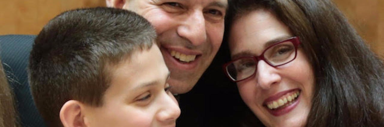 Celebrating the Bar Mitzvah of My Son With Special Needs parents smiling with their son