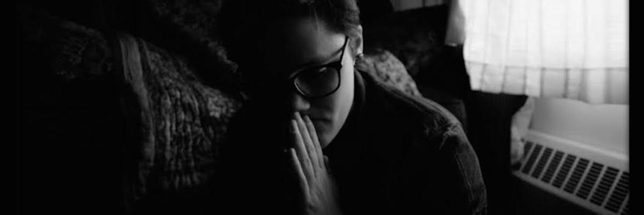 What I Wish I Could Tell People About My Schizophrenia a Black and white portrait of the author with her hands in a prayer position