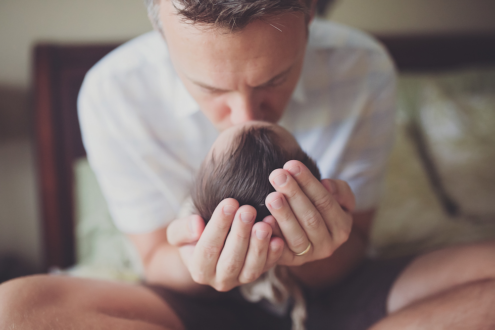 Stephen Jones kissing forehead of baby daughter Abigail