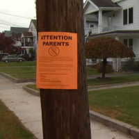 A sign that says, 'Attention Parents' on street light