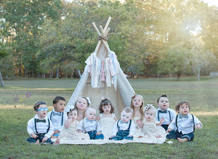 Children with Down syndrome sitting on blanket in a park