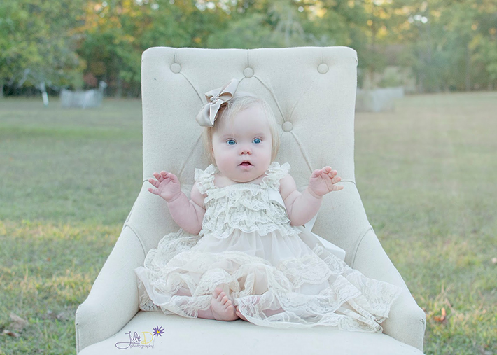 Baby girl sitting on a chair in a park