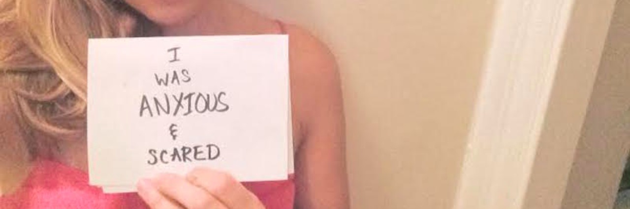 Stop Stigmatizing People With Mental Illness woman holding sign up to mirror