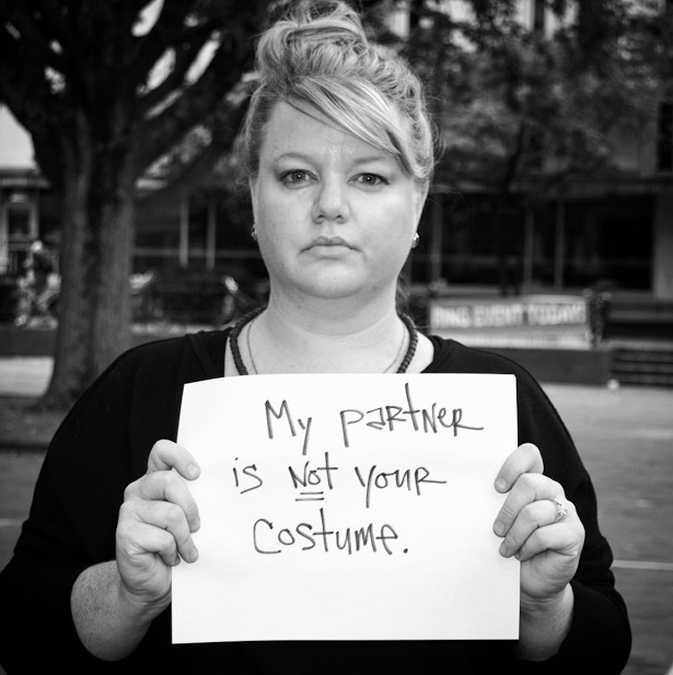 mental health advocate holding a sign that says 'my partner is NOT your costume'