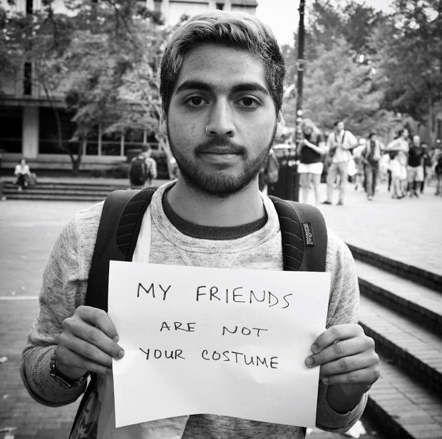 mental health advocate holds sign saying 'my friends are not your costume'