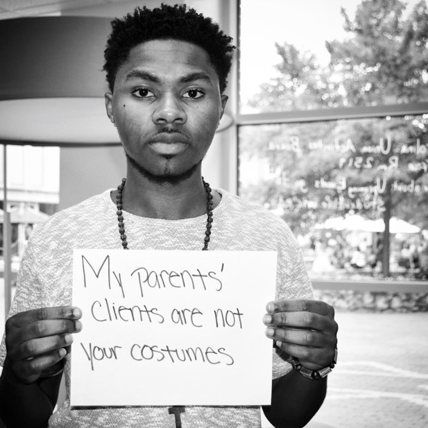 mental health advocate holds sign saying 'my parents' clients are not your costumes'