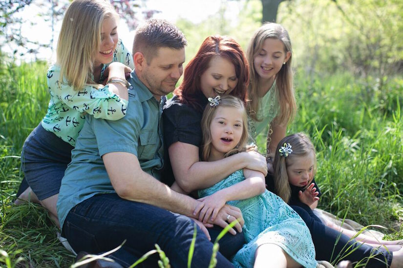 Gillian's family sitting on the grass in a park