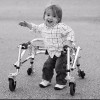 black and white photo of a toddler using a walker