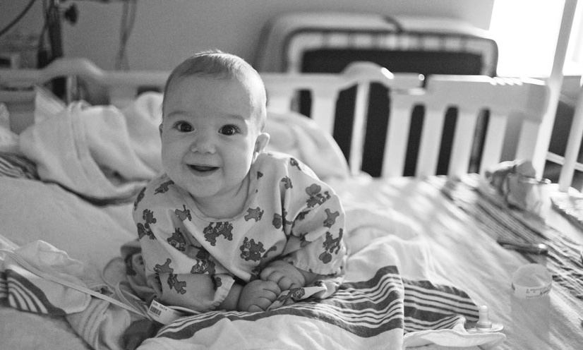 Baby sitting in a crib. 