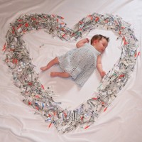 baby surrounded by syringes in shape of heart