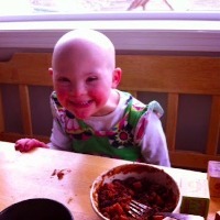 author's daughter smiling at the kitchen table