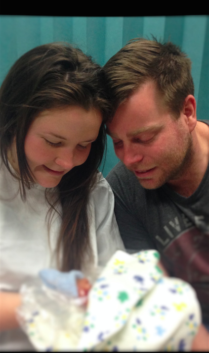 mother and father looking down at child