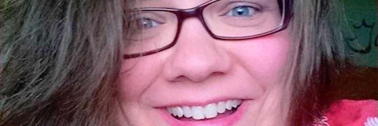 Why My ADHD Diagnosis Changed My Life for the Better A woman with glasses smiling into camera