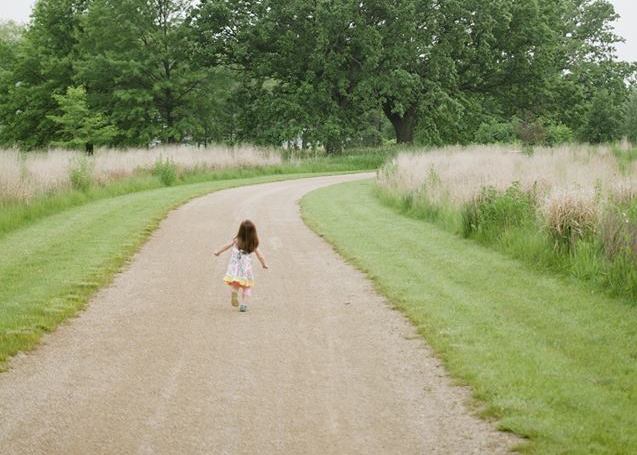 young girl walking down a path