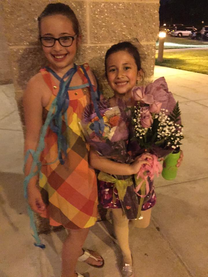 Two girls holding flowers.