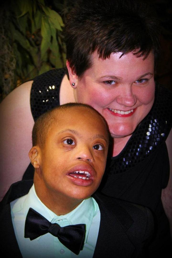 A woman smiling with a young boy in a tux. 