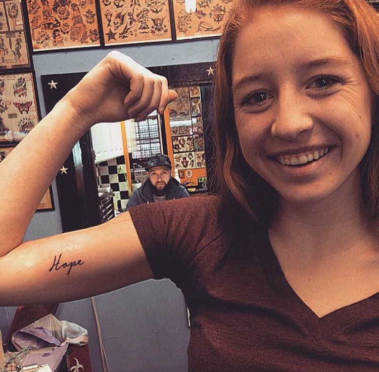 Woman with the word "Hope" written on her upper arm