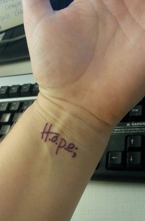 A tattoo of the word "H.o.p.e;"