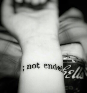 Tattoo that says "; not ended" on wrist