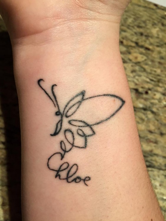 A tattoo of an illustration of a butter fly with Chloe written underneath