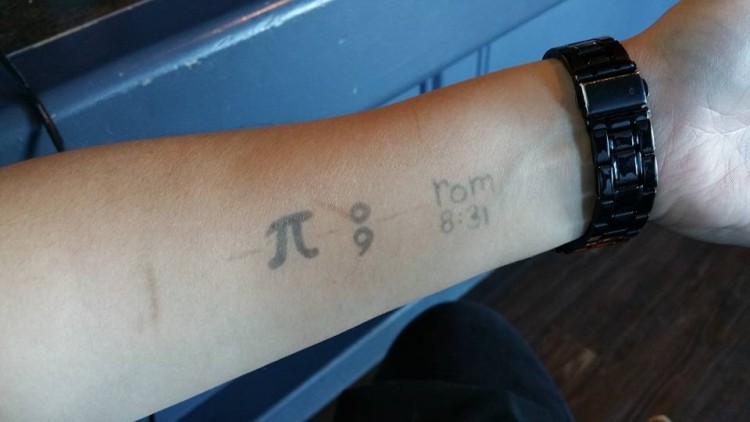 Tattoos of the Pi symbol, a semi-colon and Rom 8:31 on forearm