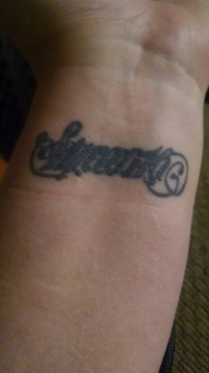 A tattoo that reads "strength" one way and "serenity" the other way