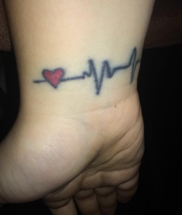 Tattoo of a red heart next to a heartbeat line
