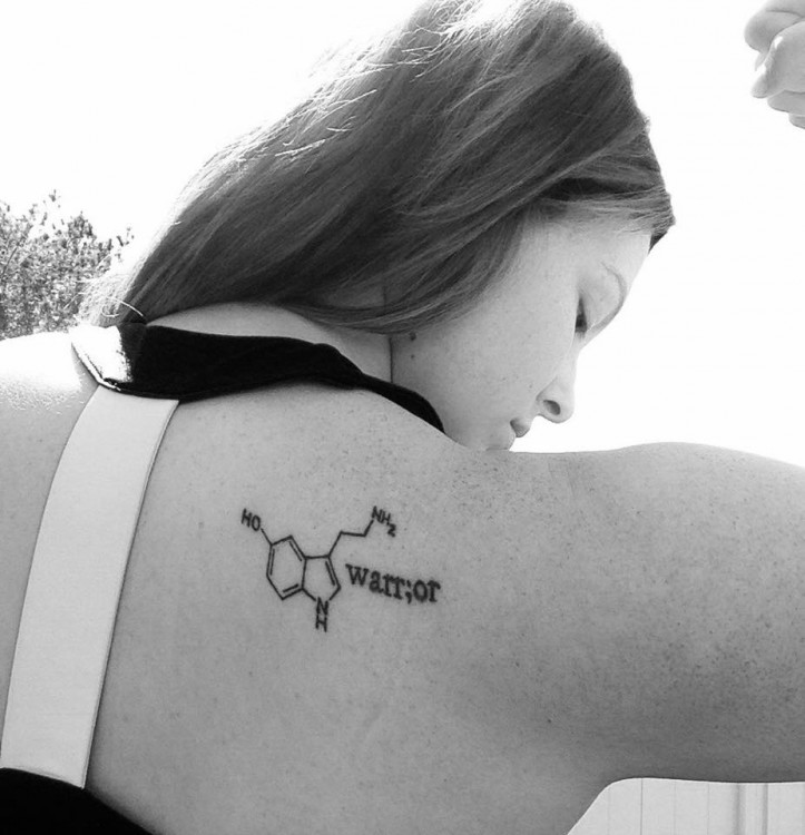 Woman with serotonin chemical formula tattoo on back