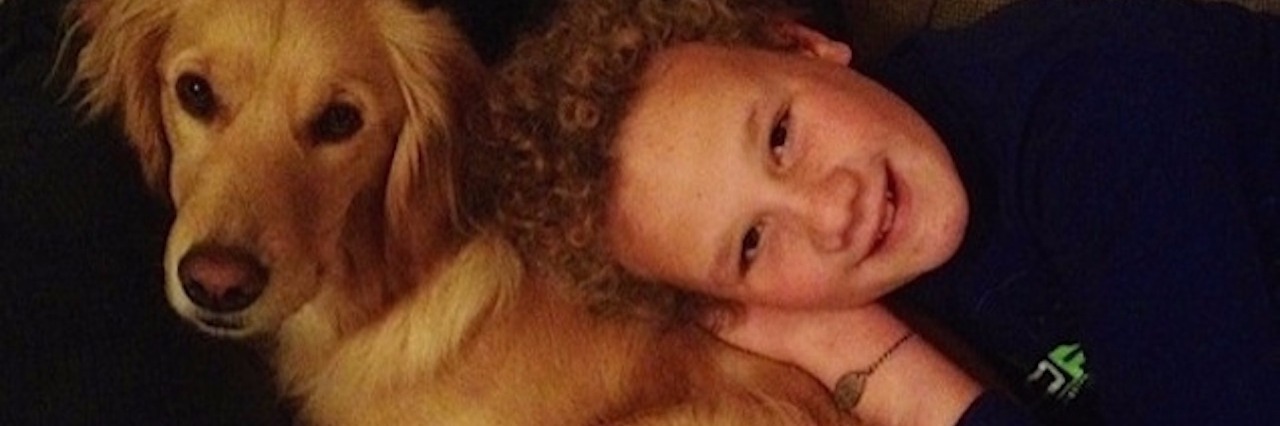 Celebrating Thanksgiving With My Son on the Autism Spectrum boy laying next to his dog