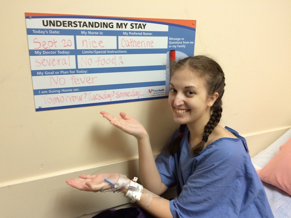 a woman in a hospital displaying a medical chart with her information