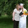 A mom kissing her daughter in a cap and gown on the cheek on her graduation day