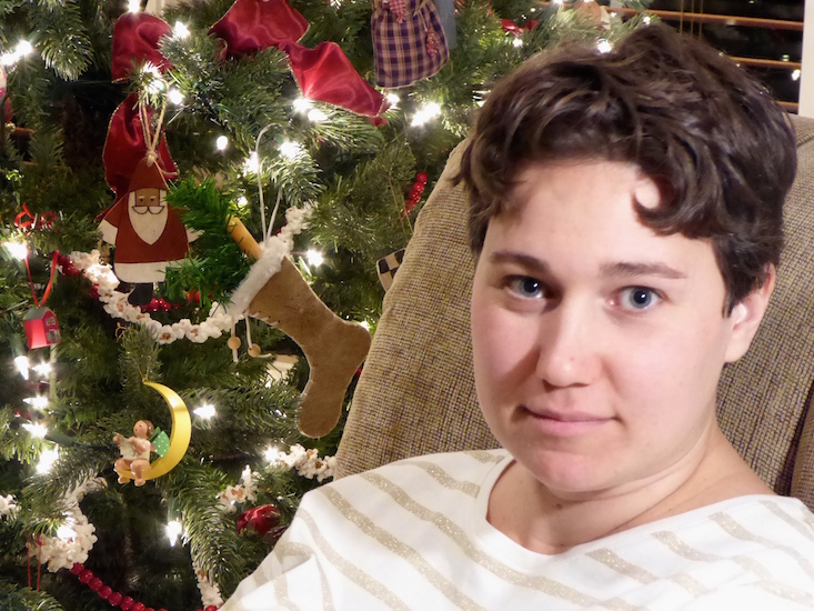 woman sitting by Christmas tree