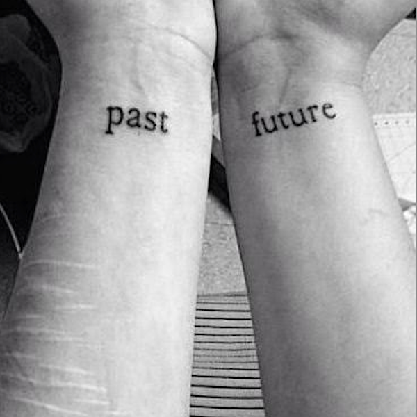 The words "past" and "future" written on two wrists