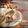 Autumn rustic table setting with berries, leaves, acorns and nuts