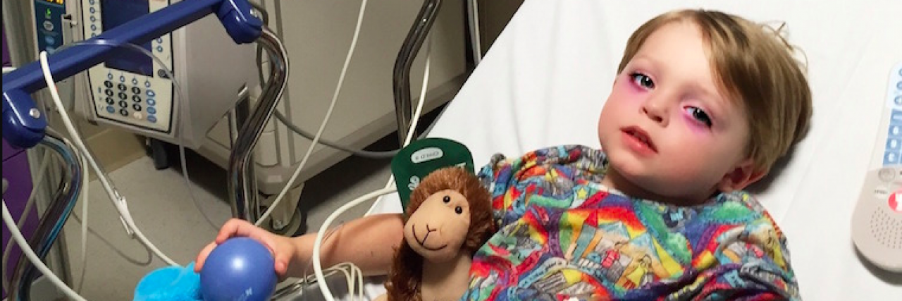 When One Second Changes Your Life as a Parent Young boy laying in hospital bed with stuffed animal
