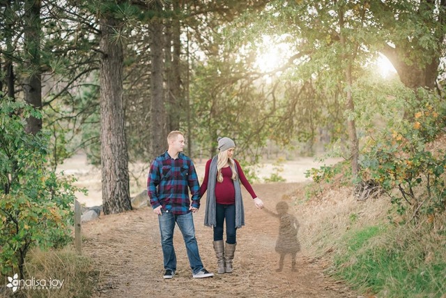 A photo of the author and her husband walking through a forest, holding the hand of a silhouette of her child