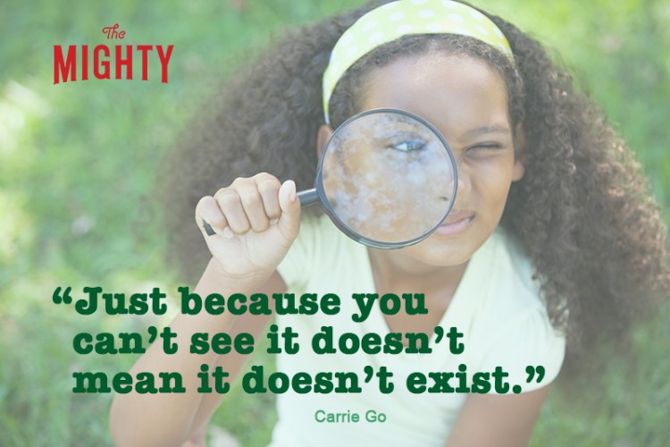 Young girl looking through magnifying glass in the park