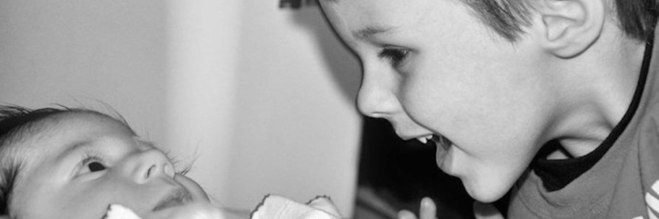 young boy smiling at baby