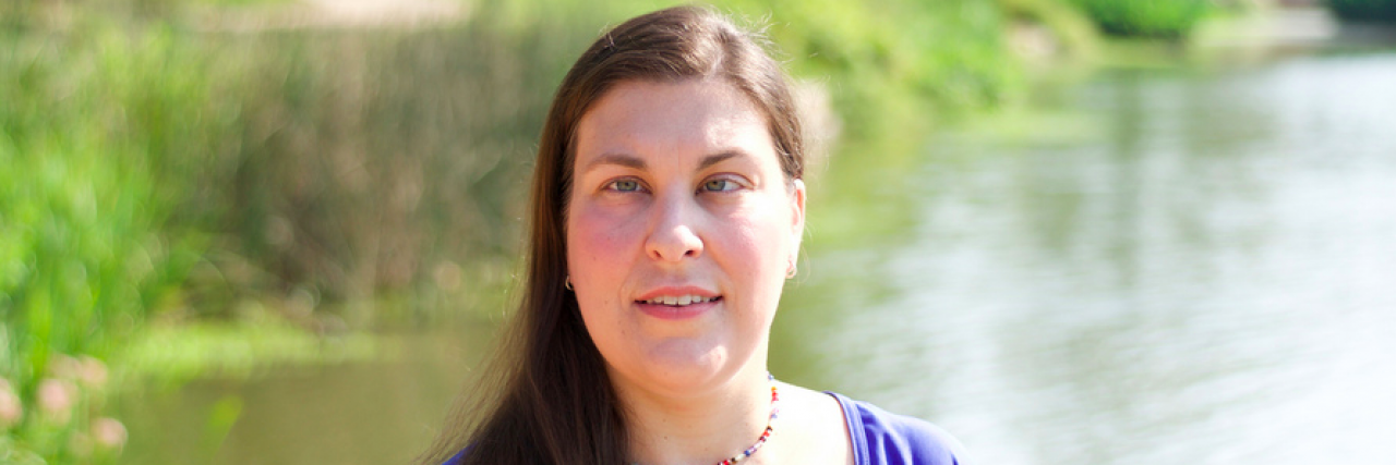 What It's Like to Be Legally Blind Contributor Natasha Baebler with a pond and plants behind her