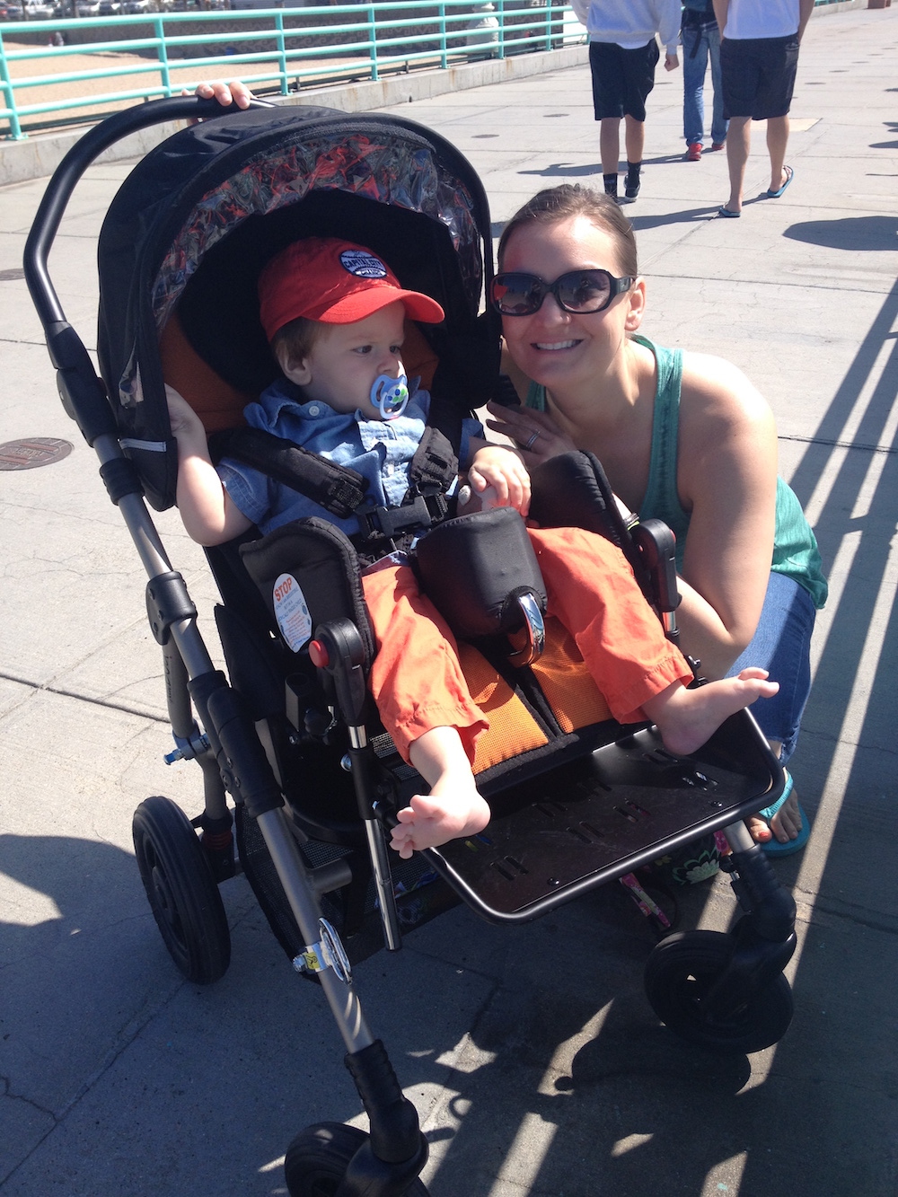 mom smiling next to son in stroller