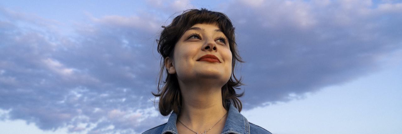 Autism Myths People Affected by It Want to See Busted Woman smiling with water and clouds behind her